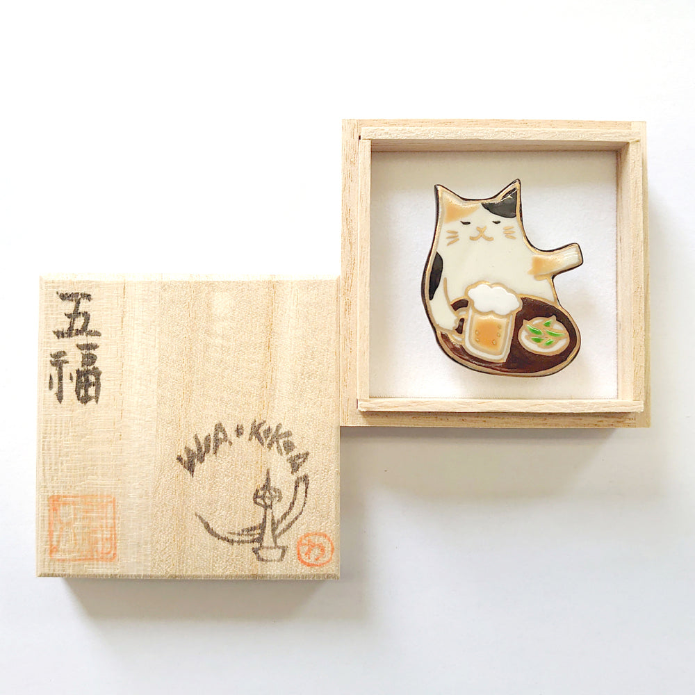 帯留め おつかれにゃ~ん(ミケ猫)|五福 × WA・KKA オリジナル帯留め|陶芸家・五福香菜子|清水焼|サイズ:縦約4cm幅約3.5cm高さ約1cm|品質:陶製(桐箱入り)