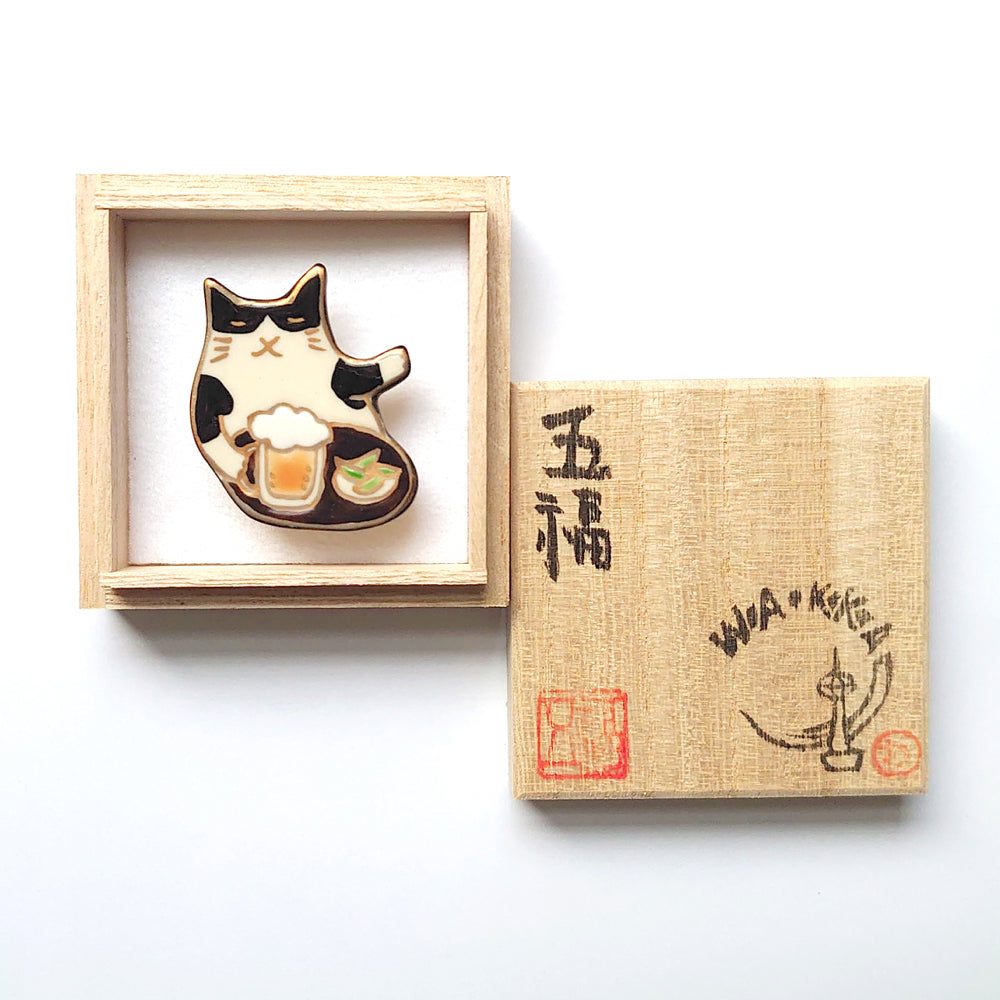 帯留め おつかれにゃ~ん(ハチワレ猫)|五福 × WA・KKA オリジナル帯留め|陶芸家・五福香菜子|清水焼|サイズ:縦約4cm幅約3.5cm高さ約1cm|品質:陶製(桐箱入り)